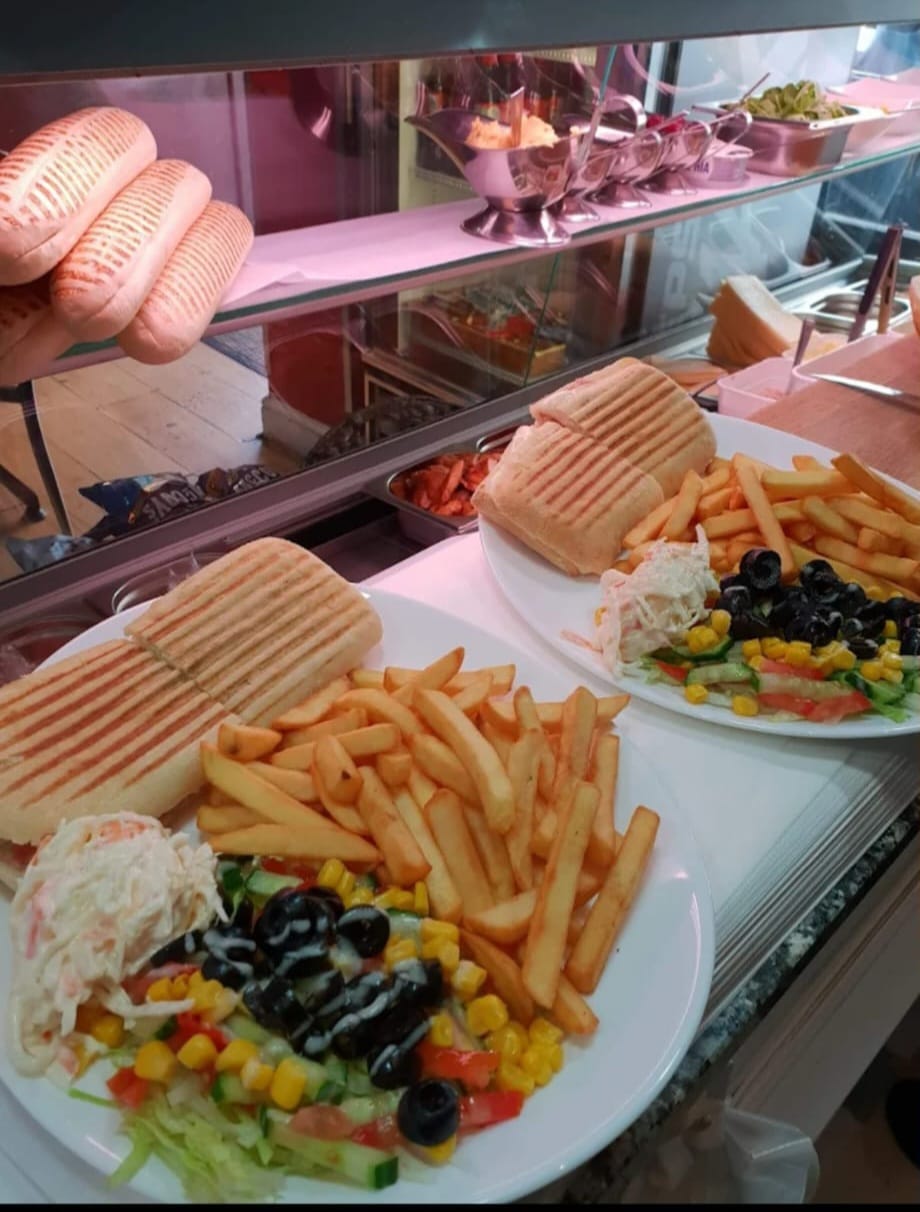 Panini with chips and salad served at the counter